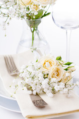 table setting with roses in bright colors and vintage crockery