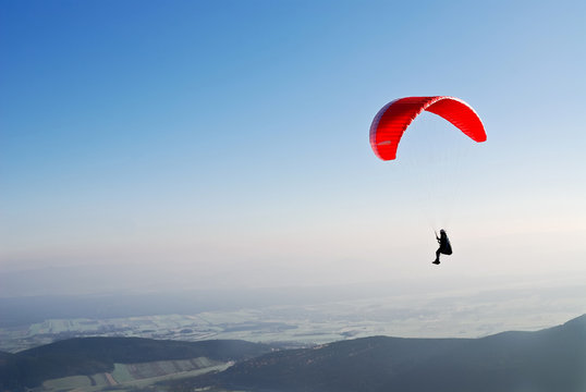Roter Paragleiter am Himmel