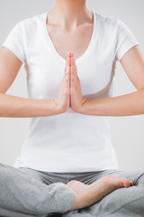 A young woman sitting in the lotus position while meditating