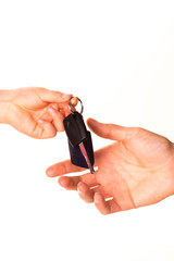 Male hand holding a car key and handing it over isolated