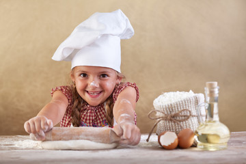 Happy little chef stretching the dough