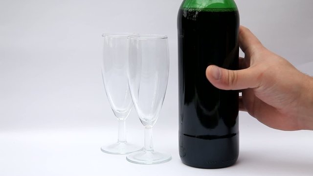 Red wine poured from a bottle into two wine glasses