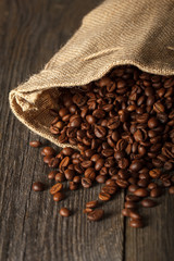Coffee bag with coffee beans on wooden surface. Focused in cente