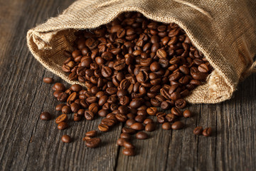 Coffee bag with coffee beans on wooden table. Focused in center 