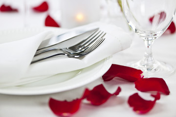 Romantic dinner setting with rose petals