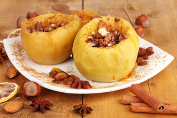 Baked apples on plate on wooden table