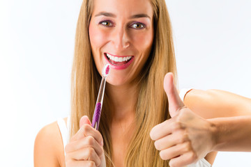 Woman brushing her teeth with a toothbrush