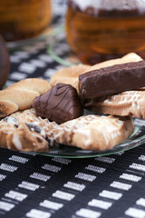 Plate with cookies next to two cup of tea