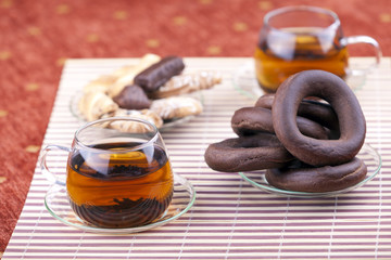 Two cups of tea with two plates with cookies
