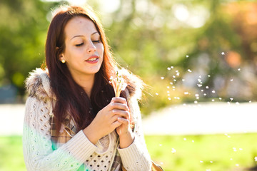 Girl with dandelion on green field