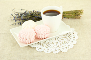 Marshmallows on plate on light background