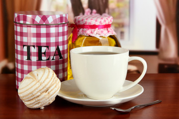 Jar and cup of tea on table in room