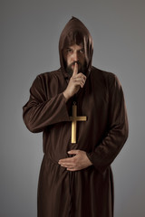 Monk in brown robe asking for silence