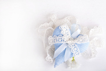 blue textile heart with a  bow from lace