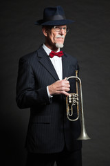 Senior jazz musician. Trumpet player. Studio shot.