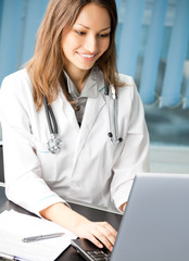 Cheerful female doctor with laptop