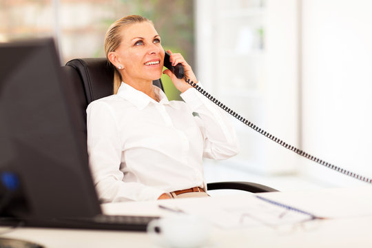 Mid Age Businesswoman Talking On The Phone In Office