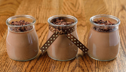 Chocolate dessert in a small glass jar on a brown table