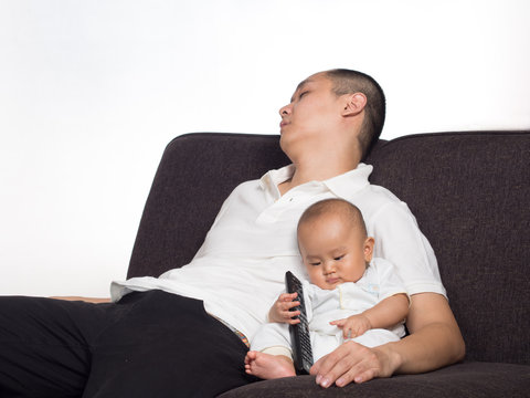 Sleeping Dad In Front Of TV With Baby