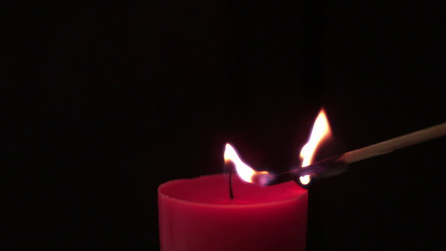 Pink candle lit by match