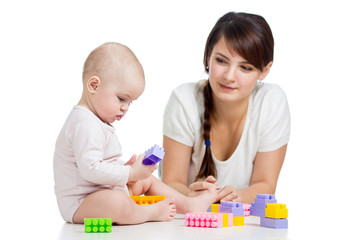 Obraz na płótnie Canvas baby girl and mother playing together with construction set toy