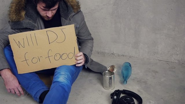 homeless dj sitting on the floor upset