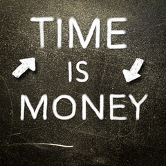 Time is money handwritten with white chalk on a dark background