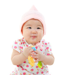 Asian baby girl gripping a toy