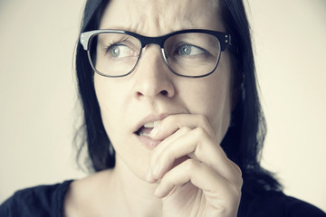 Zweifelnde Frau mit Brille