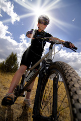 Woman Mountain Biking and Sunshine