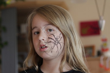 Mädchen geschminkt mit Spinne für Karneval oder Halloween