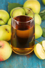 Useful apple juice with apples around on wooden table