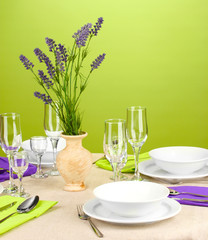 Table setting in violet and green tones on color  background