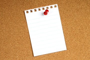 White note with pin on wooden background .
