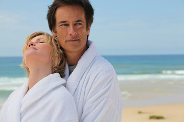 Couple in bathrobes on the beach