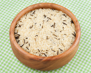 white and wild rice in wooden  bowl on kitchen table