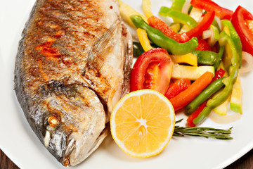 Grilled dorado fish with lemon and vegetables