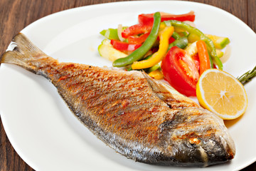 Grilled dorado fish with lemon and vegetables