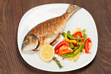 Grilled dorado fish with lemon and vegetables