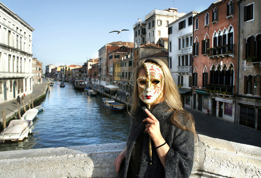 Woman in beautiful Venetian mask in Venice