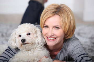 Woman lying on rug with poodle