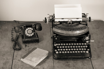 Vintage (1940th) old typewriter, phone, book on table