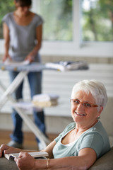 enior woman smiling and a young woman folding laundry