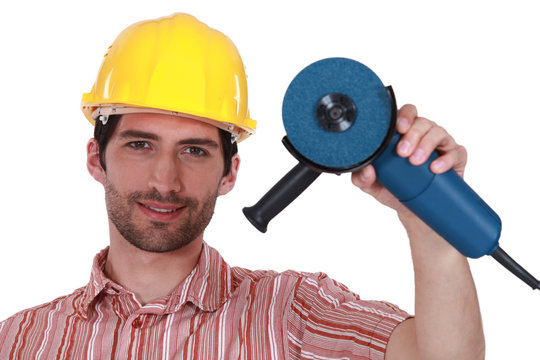 Head And Shoulders Portrait Of Craftsman Holding Tool