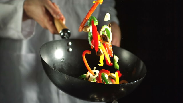 Chef making vegetable stir fry in wok