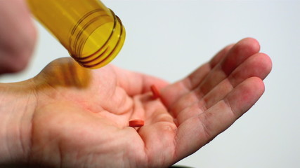 Two red tablets being poured into open palm - Powered by Adobe