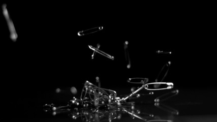 Many safety pins crashing to floor - Powered by Adobe