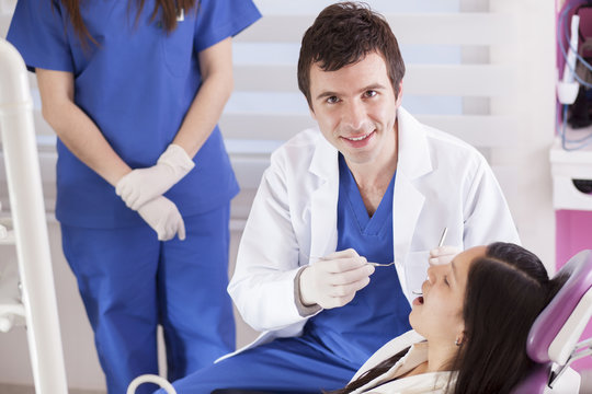 Handsome young dentist working on a patient
