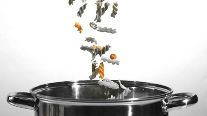 Tricolour fusilli falling into a saucepan - Powered by Adobe