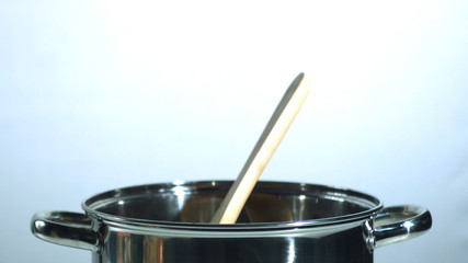 Wooden spoon falling in a saucepan - Powered by Adobe